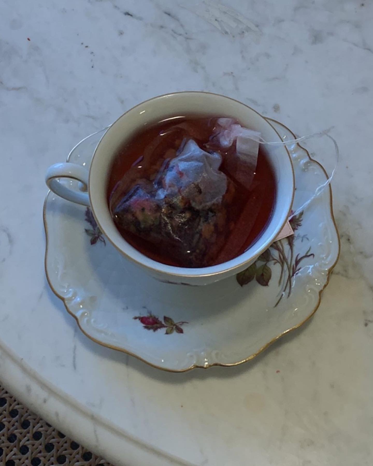 Tea filter from Gilded Coach Teas in a vintage white tea cup with tea inside