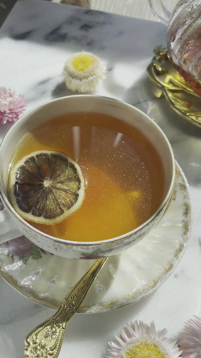 Black Tea with edible glitter (Pixie Dust) from Gilded Coach Teas shimmering in a vintage tea cup